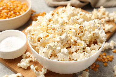 Açık gri masada patlamış mısır ve mısır taneleri, yakın plan.