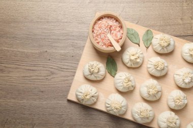Pişmemiş khinkaliler (hamur tatlısı) ve ahşap masa üzerindeki baharatlar, üst manzara. Metin için boşluk