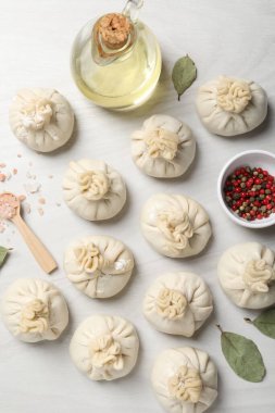 Pişmemiş khinkaliler (hamur tatlısı) ve beyaz ahşap masa üzerindeki baharatlar, düz konum