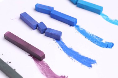 Beyaz arkaplanda renkli tebeşirler, yakın plan