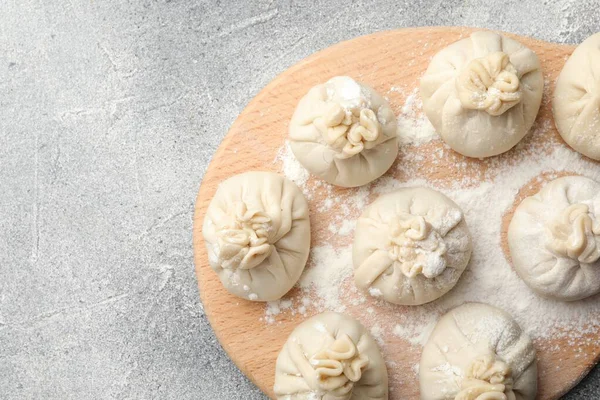 Üzerinde un olan pişmemiş khinkaliler (hamur köfteleri), en üstte. Metin için boşluk