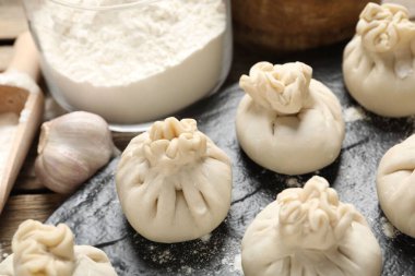 Pişmemiş khinkaliler (hamur tatlısı), un ve sarımsak masada, yakın plan.