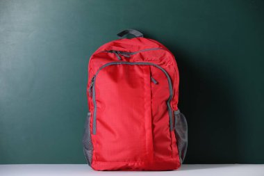 Masanın yanındaki kırmızı sırt çantası. Okula geri dön.