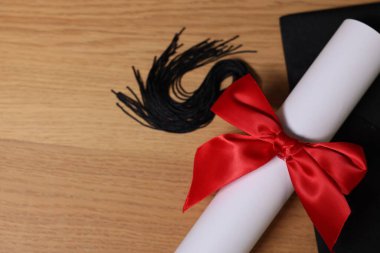 Mezuniyet şapkası ve diploması tahta masada, düz yatıyordu. Metin için boşluk