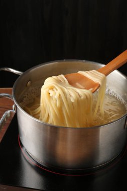 Haşlanmış tagliatelle makarnasını elektrikli ocaktan kaşıkla alıp, yakın plan çekiyoruz.
