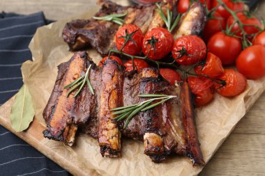 Biberiyeli biftek kaburgaları ve ahşap masada domatesler, yakın plan.