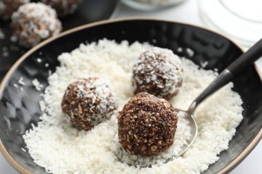 Beyaz masada fındıklı ve hindistan cevizli lezzetli çikolatalar yapmak, yakın plan.