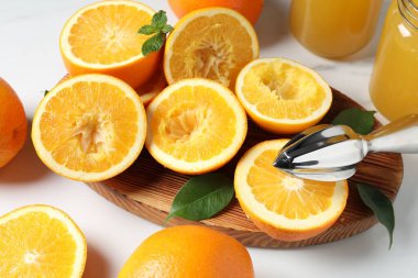 Sıkıştırıcı, portakal ve nane şekeri beyaz masada, yakın plan. Taze meyve suyu.