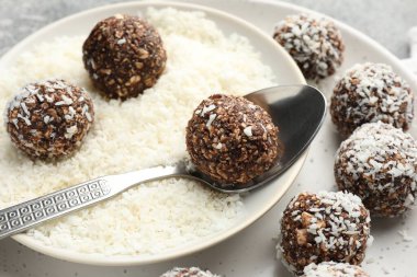 Gri masada hindistan cevizi gevreğiyle lezzetli çikolatalar yapmak, yakın plan.