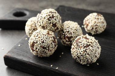 Gri masada fındıklı ve susamlı çikolatalı şekerler, yakın plan.