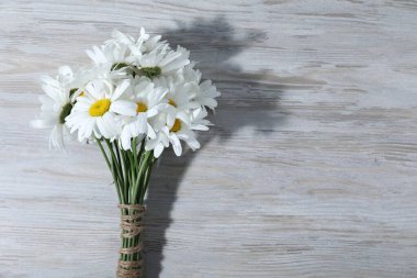 Gri ahşap masadaki güzel papatya çiçekleri, üst manzara. Metin için boşluk