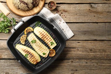 Baharatlı lezzetli ızgara kabak dilimleri ve ahşap masada limon, düz yatak. Metin için boşluk