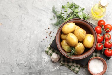 Lezzetli, dereotlu haşlanmış patates, kasede yağ, gri desenli masada tuz ve ürünler, düz yatak. Metin için boşluk