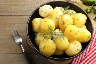 Lezzetli, taze haşlanmış patatesler kase ve çatalla ahşap masada, yakın plan.