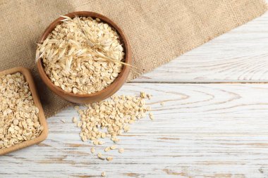 Kasedeki yulaf gevrekleri, kaşık, çiviler ve bez bezi açık ahşap masada, düz yerde. Metin için boşluk