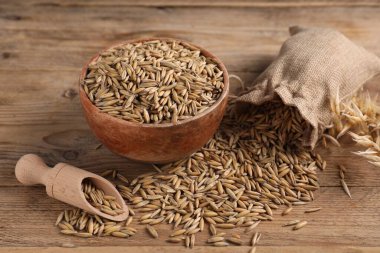 Yulaf taneleri, kepçe, kase ve çuval tahtada, yakın plan.