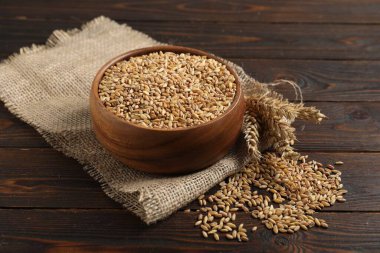 Tahta masadaki buğday taneleri, çiviler ve çuval bezi, yakın plan.