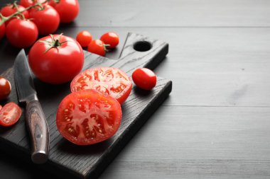 Siyah masada bıçaklı kırmızı domatesler, yakın plan. Metin için boşluk