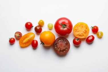 Beyaz masada farklı olgun domatesler, düz yatıyordu.
