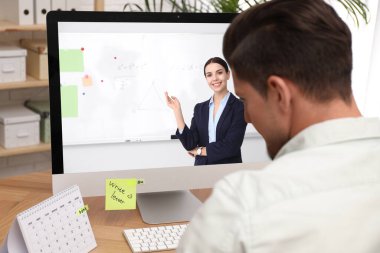 E-öğrenme konsepti. Öğrenci masadaki bilgisayar aracılığıyla öğretmenle çevrimiçi görüntülü sohbet ediyor