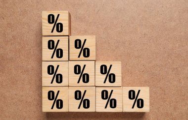 Kahverengi desenli arka plan üzerinde yüzde işaretleri olan tahta küpler, üst görünüm