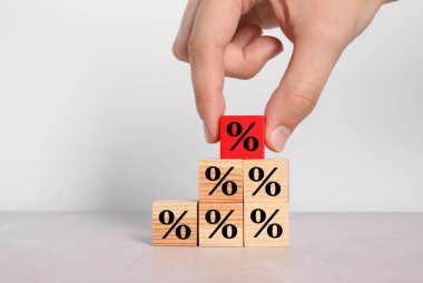 Beyaz arkaplana karşı yüzde işaretli kırmızı küp koyan adam, yakın plan