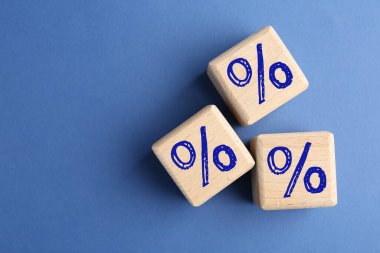 Mavi arka planda yüzde işaretleri olan tahta küpler, üst manzara. Metin için boşluk