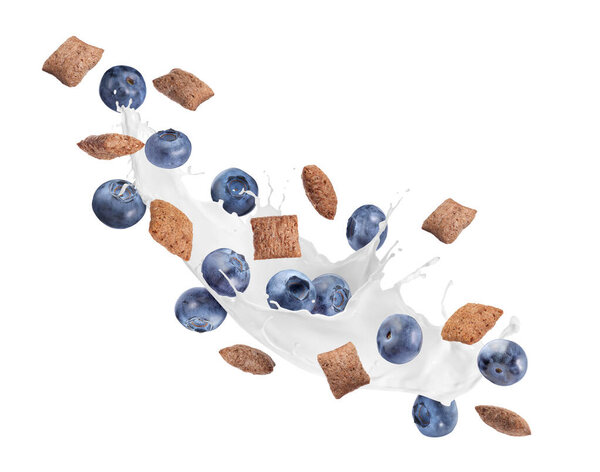 Splashing milk with sweet corn pads and fresh blueberries in air against white background. Healthy breakfast