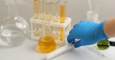 Bilim adamı suyu beyaz masada kalite ölçer ile test ediyor.