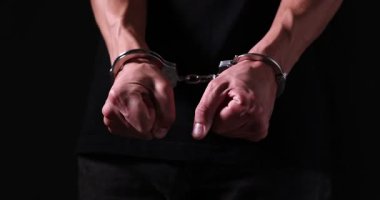 Siyah arka planda metal kelepçeli adam, yakın plan.