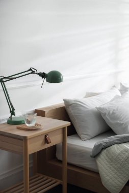 Yatağın yanında dekoru olan bir komodin.