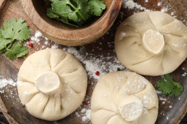 Ahşap masada biber ve maydanozlu pişmemiş khinkaliler (hamur tatlısı).