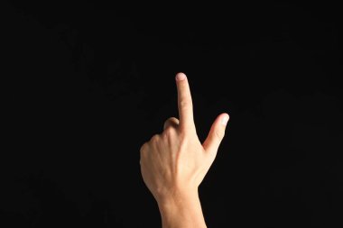 Siyah arkaplanda bir şeye dokunan adam, yakın plan