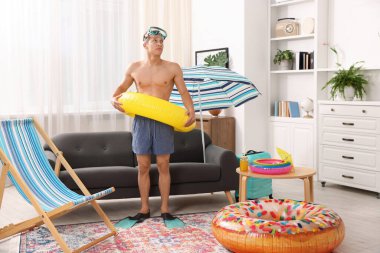 Yüzgeçli, dalış maskeli ve şişme yüzüklü bir adam. Denizde tatilin hayalini kuruyorum.