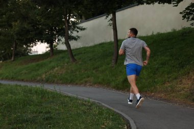 Spor kıyafetleri içinde koşan atletik genç bir adam. Metin için boşluk