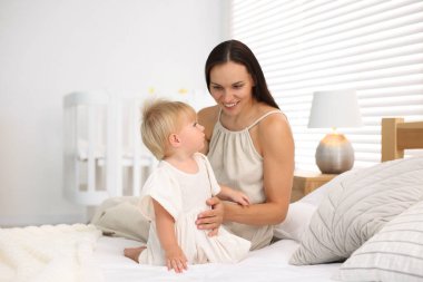 Annesi ve tatlı bebeği yataktaki odada.