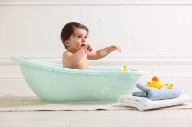 Evde küvette banyo yapan şirin bir bebek.