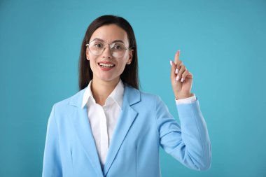 Kendine güvenen iş kadını açık mavi arka planda fikir sahibi.