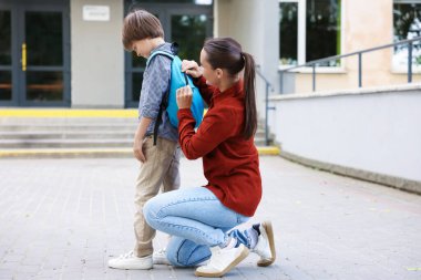 Anne oğlunu açık hava okuluna götürüyor.