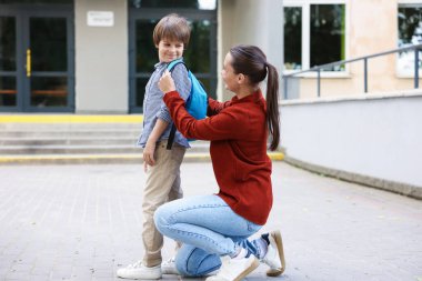 Anne oğlunu açık hava okuluna götürüyor.
