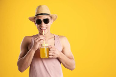 Meyve suyu ve turuncu arka planda saman içen adam, mesaj için boşluk