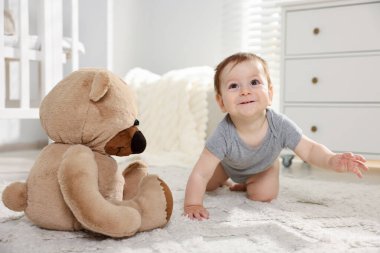 Odasında oyuncak ayı olan şirin bir bebek.