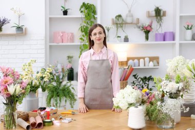 Dükkandaki ahşap masada çalışan profesyonel bir çiçekçi.