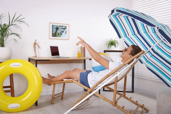 Güneş gözlüklü, plaj toplu mutlu adam evde güneşli yatakta eğleniyor. Denizde tatilin hayalini kuruyorum.