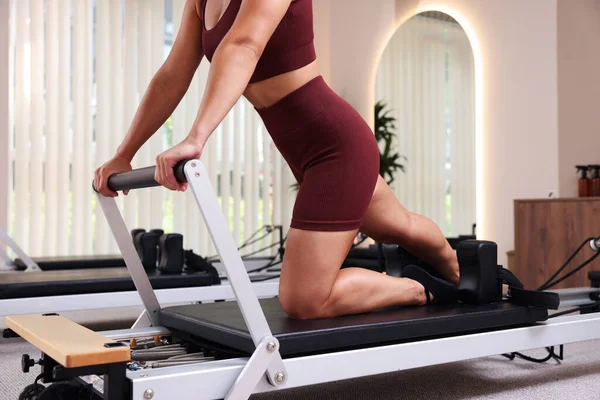 Pilates stüdyosunda yenilikçi kadın egzersizi, yakın çekim.