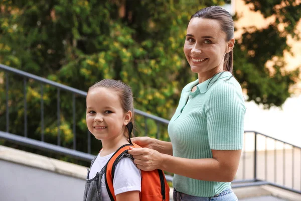Anne kızını açık hava okuluna götürüyor.