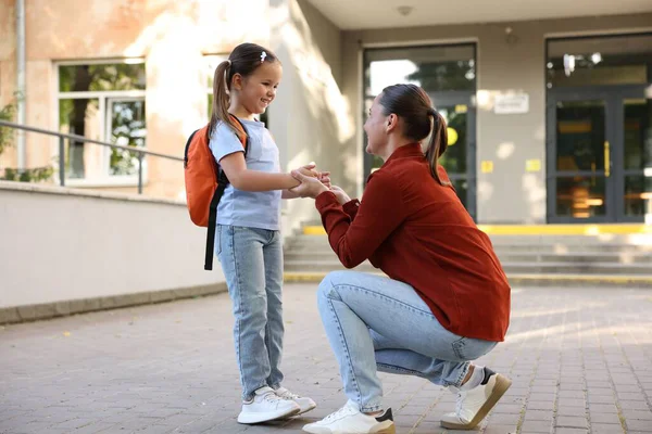 Anne kızını açık hava okuluna götürüyor.