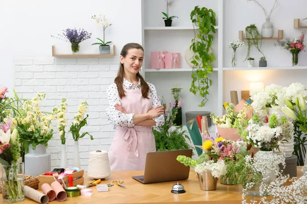 Dükkandaki ahşap masada çalışan profesyonel bir çiçekçi.