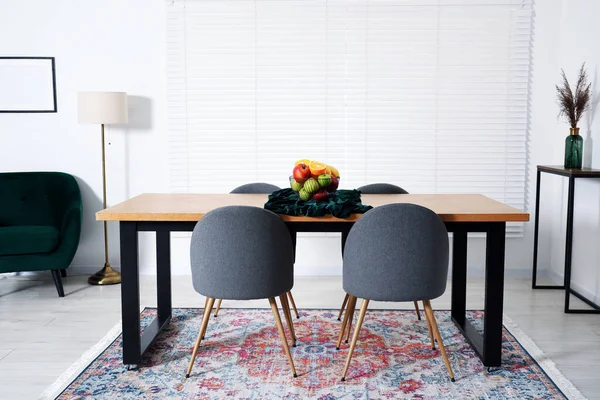 Yemek odasındaki ahşap masada bir kase meyve. İç tasarım