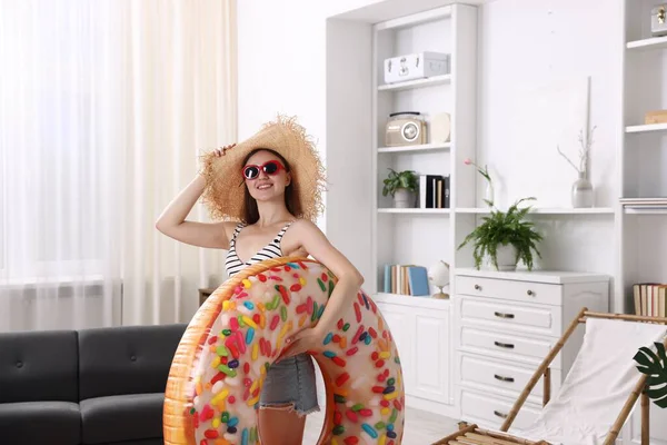 Güneş gözlüklü mutlu kadın ve evinde şişme yüzük olan hasır şapkalı. Denizde tatilin hayalini kuruyorum.